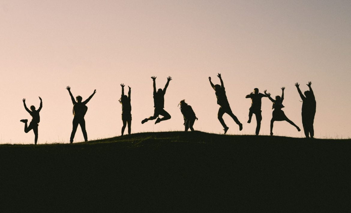People excitedly jumping on mountain