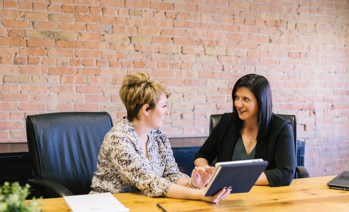 Business women sitting atconfernce table reviewing document