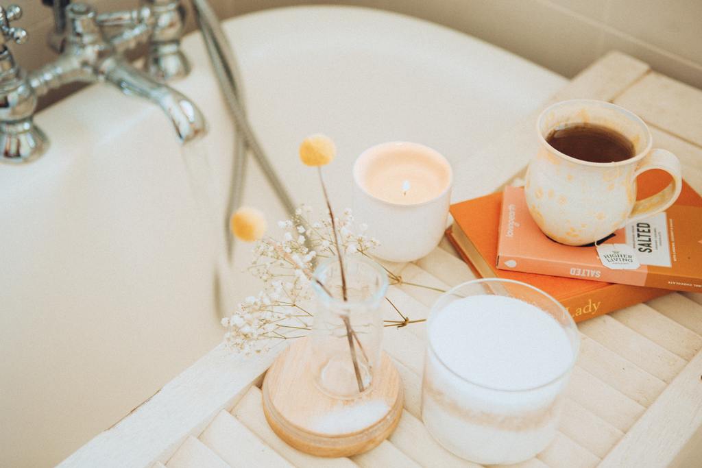 Self-Care - Bathtub with flowers, candles and coffee on the side