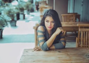 Setback: Woman sitting at table looking disappointed