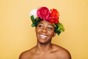 True Selves - Smiling woman wearing a crown of flowers