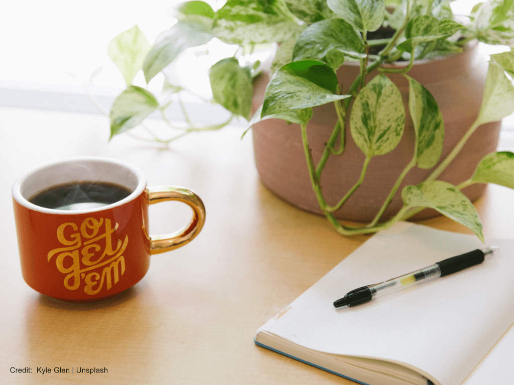 Review and Document Your Career Accomplishments - Desktop with Plant, Coffee Mug with Coffee, Open Journal with Pen