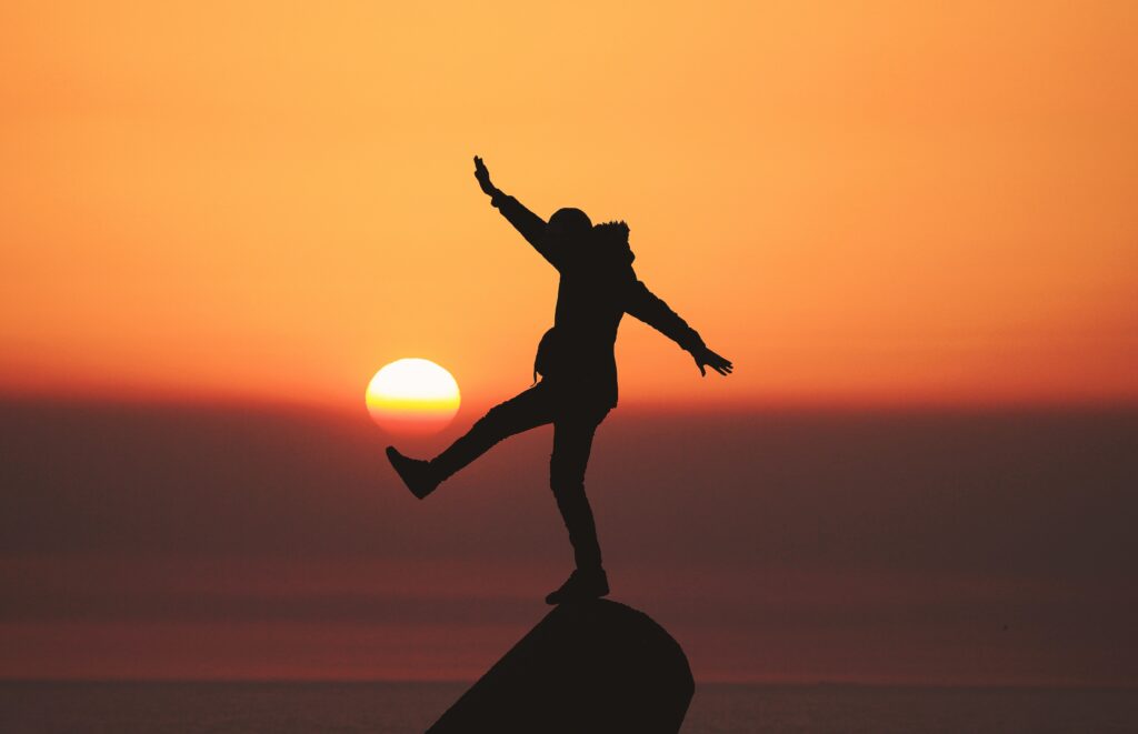Motivation | Silhouette of person balancing on rock