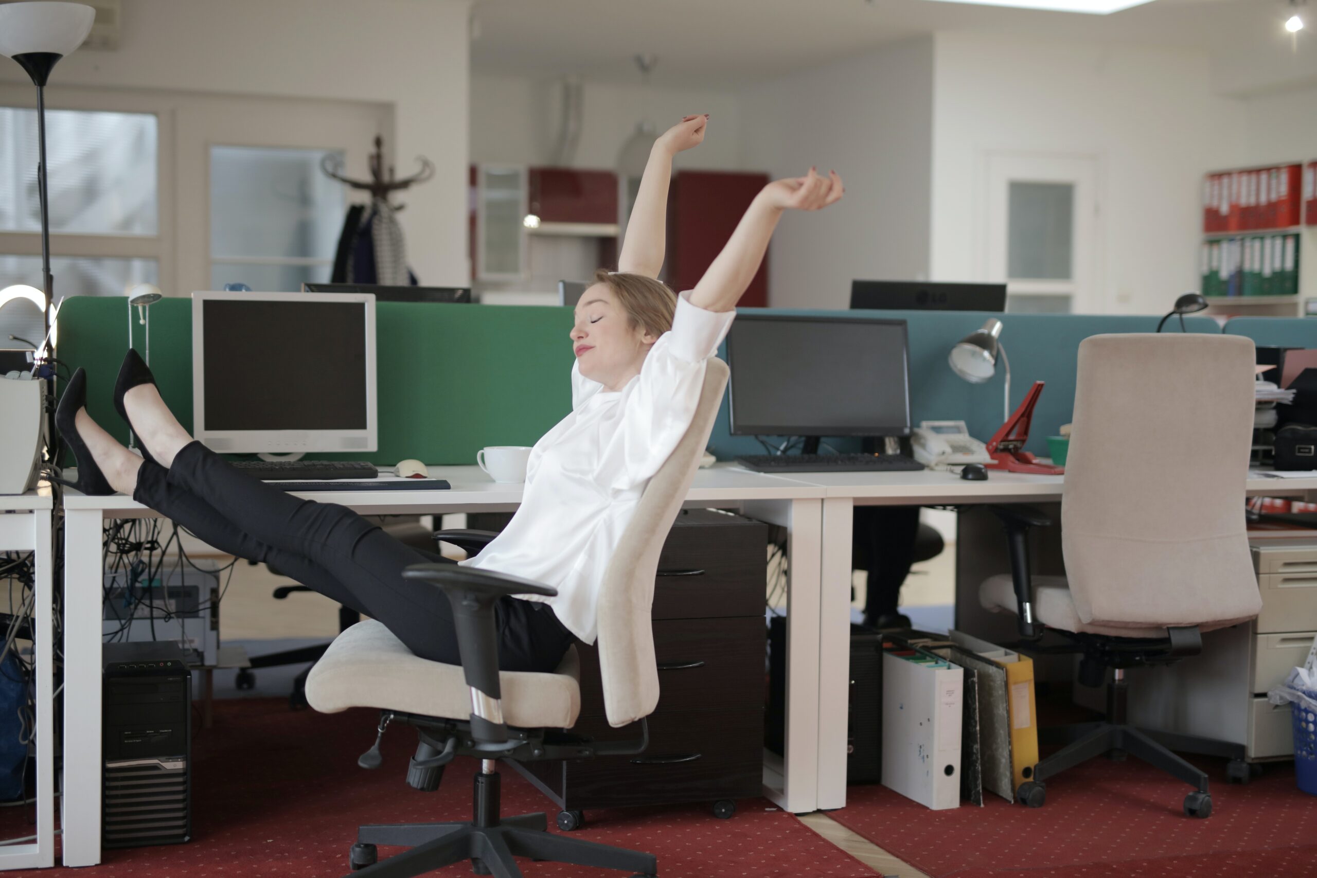 Co-worker is a slacker - woman sitting at desk with feet kicked up and yawn