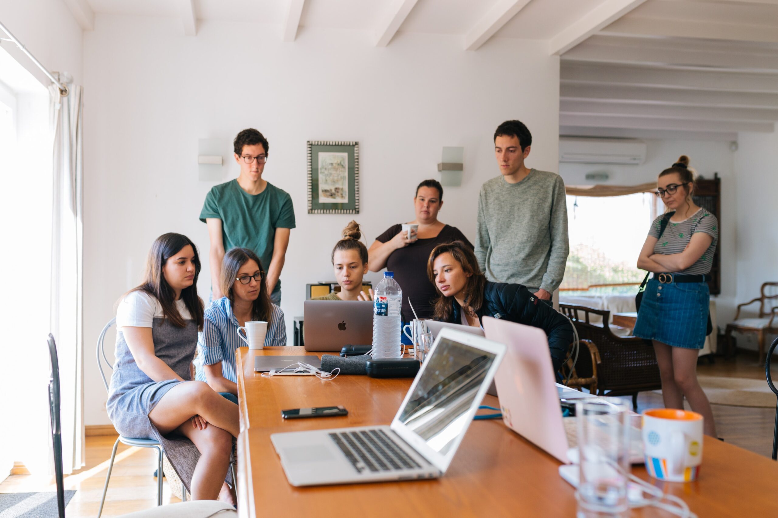 Delegate - Team of people working on project; gathered around computer