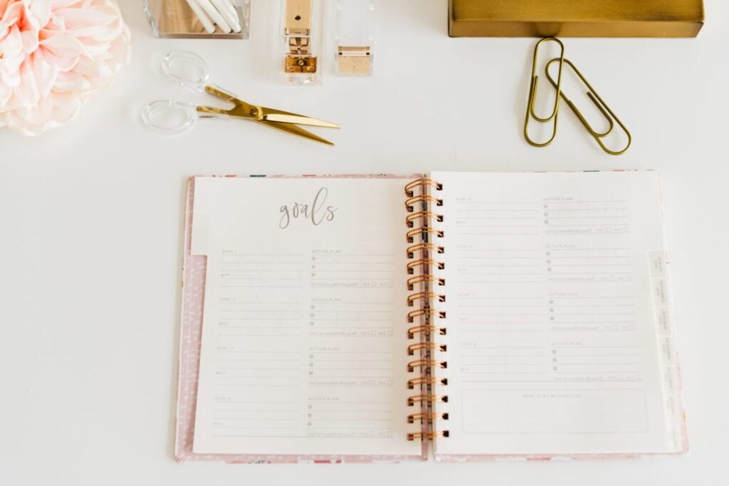 Planner is open on a desk with the words goals as the header